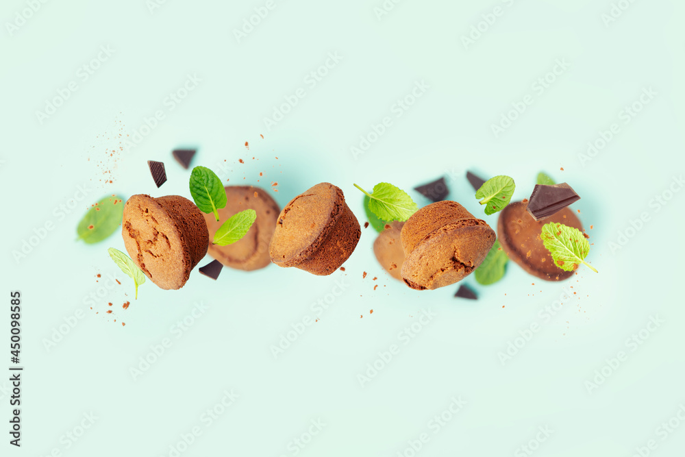 Chocolate muffins with mint leaves on blue background