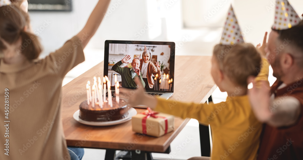 Little girl receiving congratulations from grandparents online while celebrating birthday with famil