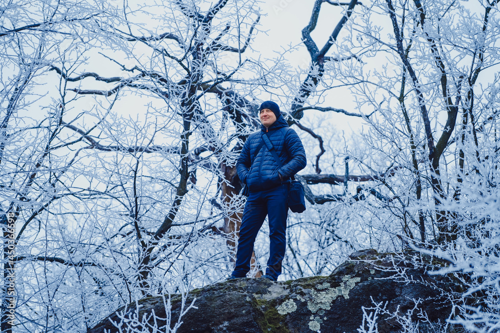 Mature photographer preparing to taking pictures in nature in late autumn with professional camera. 