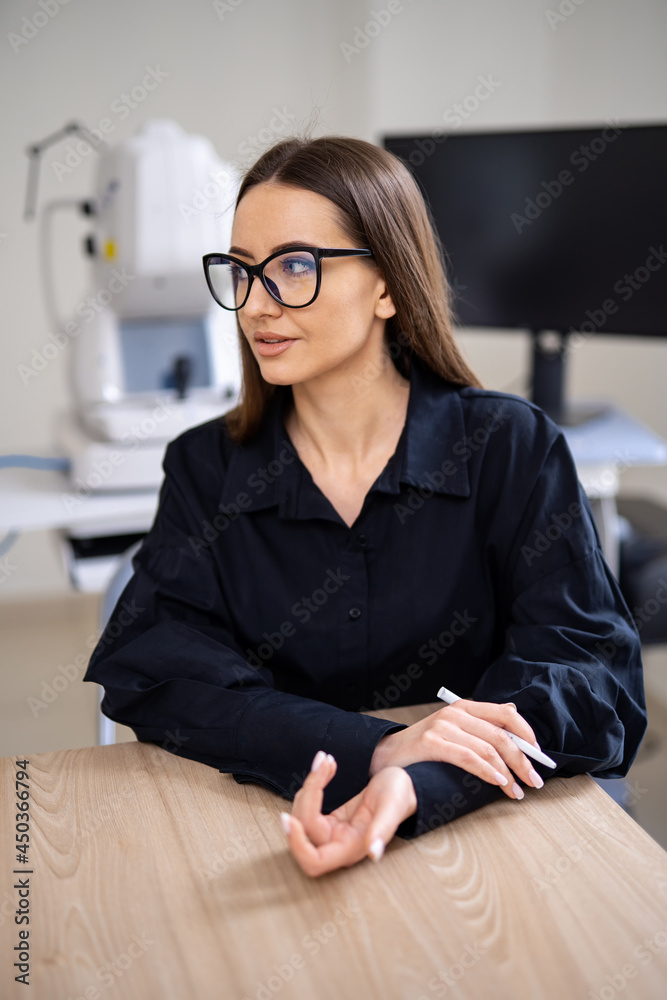 诊所里的客户戴着新眼镜。戴着屈光度眼镜的女人在看新处方