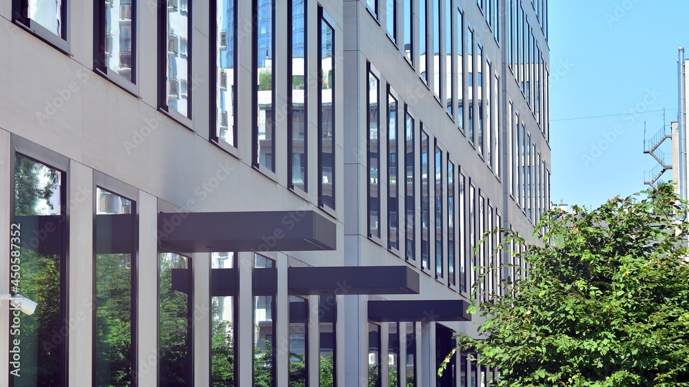 Modern glass office building with green leaves. Eco building  and greens  plants  in city concept.