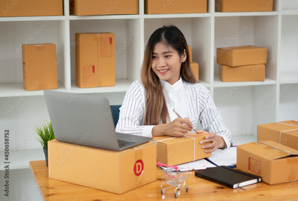 Startup small business entrepreneur SME, young asian woman working with laptop computer and delivery