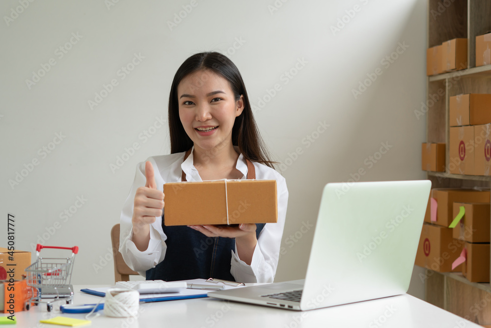 Startup small business entrepreneur SME, young asian woman working with laptop computer and delivery