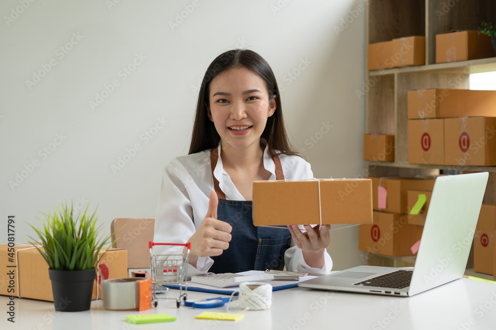 Startup small business entrepreneur SME, young asian woman working with laptop computer and delivery