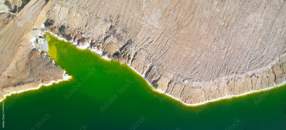 Shore of toxic green lake in abandoned open pit copper mine. its color derives from high levels of a