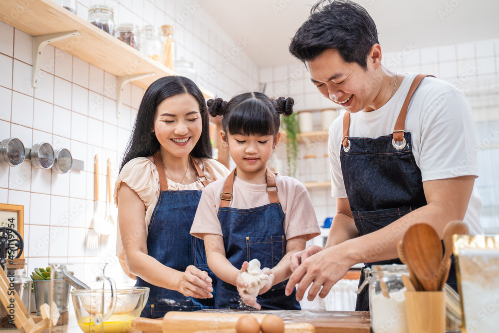 亚洲快乐家庭呆在家里的厨房、烘焙面包店和食品。