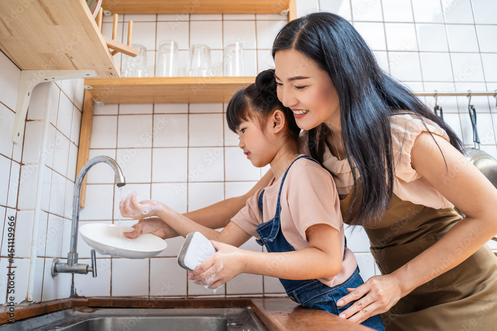 亚洲爱心妈妈教学前班女孩在家洗碗