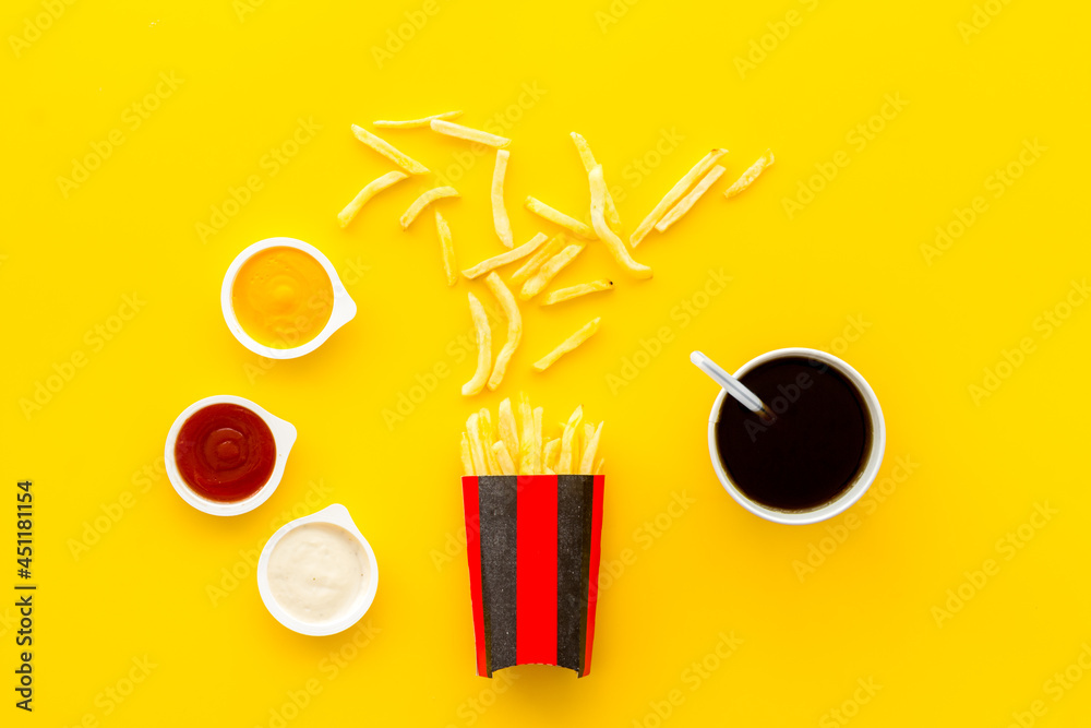 Patatoes french fries in red paper box with different sauces