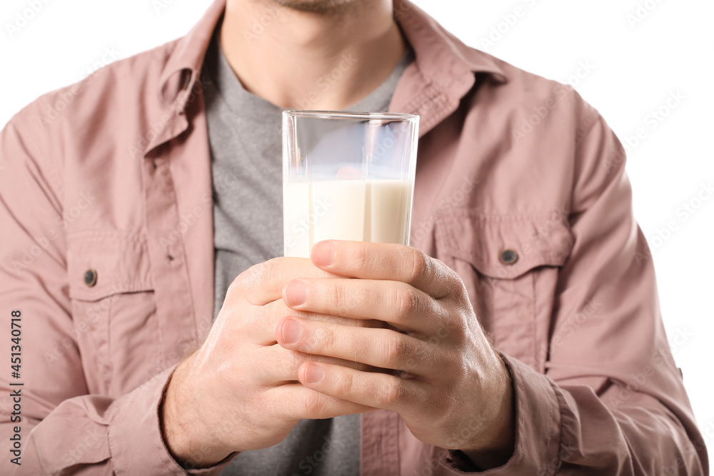 Young man with glass of milk on white background, closeup