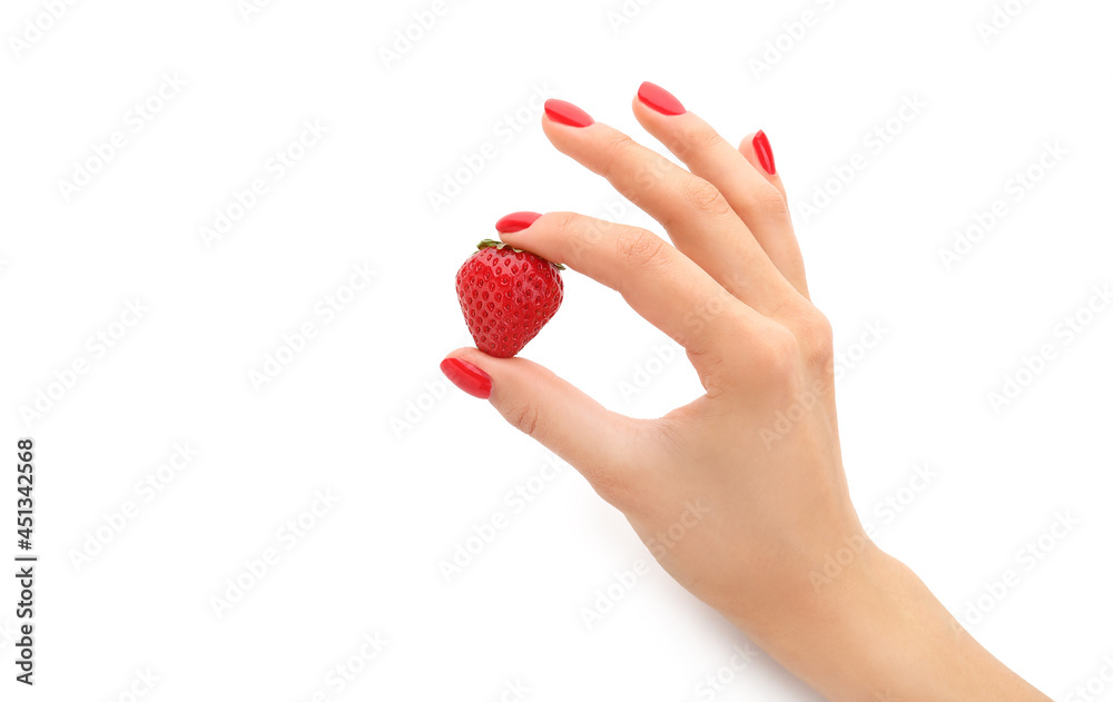 Female hand with beautiful manicure holding strawberry on white background