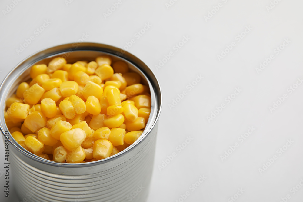 Opened tin can of corn kernels on white background