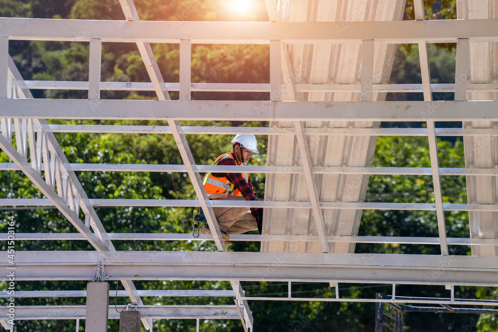 Roofer working in protective work wear gloves,Construction worker wearing safety harness working at 