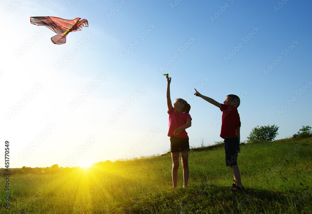 Happy kids boy and girl run with kite