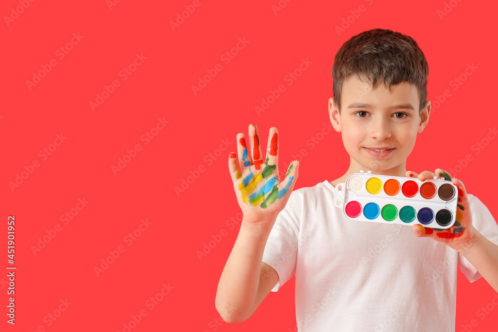 Little boy with paints on color background