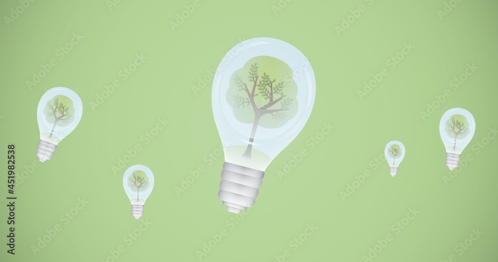 Composition of trees in light bulbs over green background on