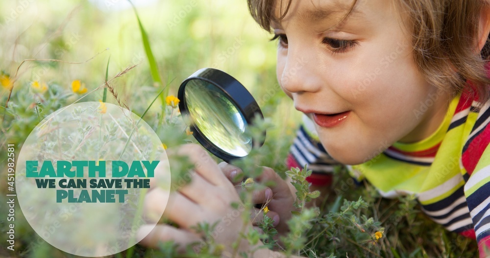 Composition of earth day logo and text over boy using magnifying glass