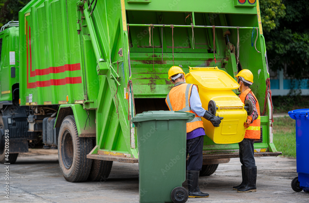 Garbage collection service,Rubbish cleaner man in a uniform working together on emptying dustbins fo