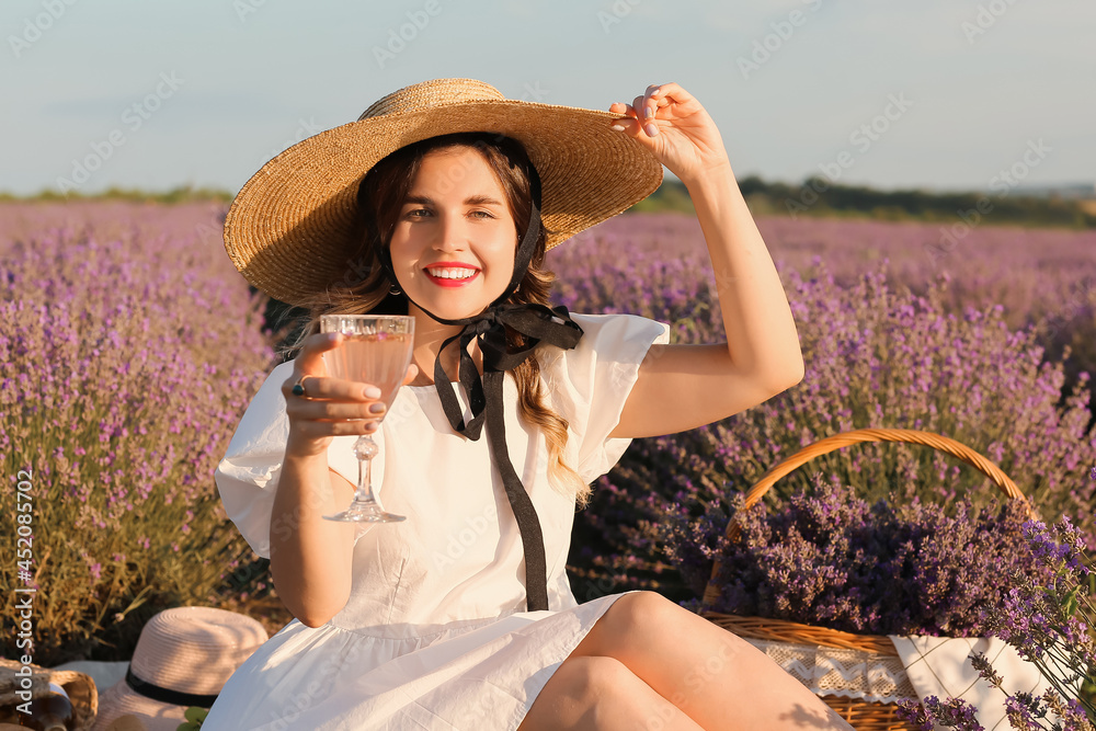 美丽的年轻女子在薰衣草地野餐