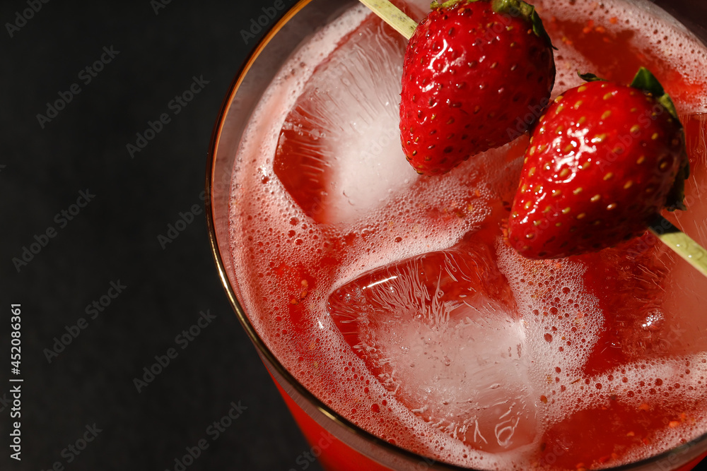 Glass of tasty strawberry margarita on dark background, closeup