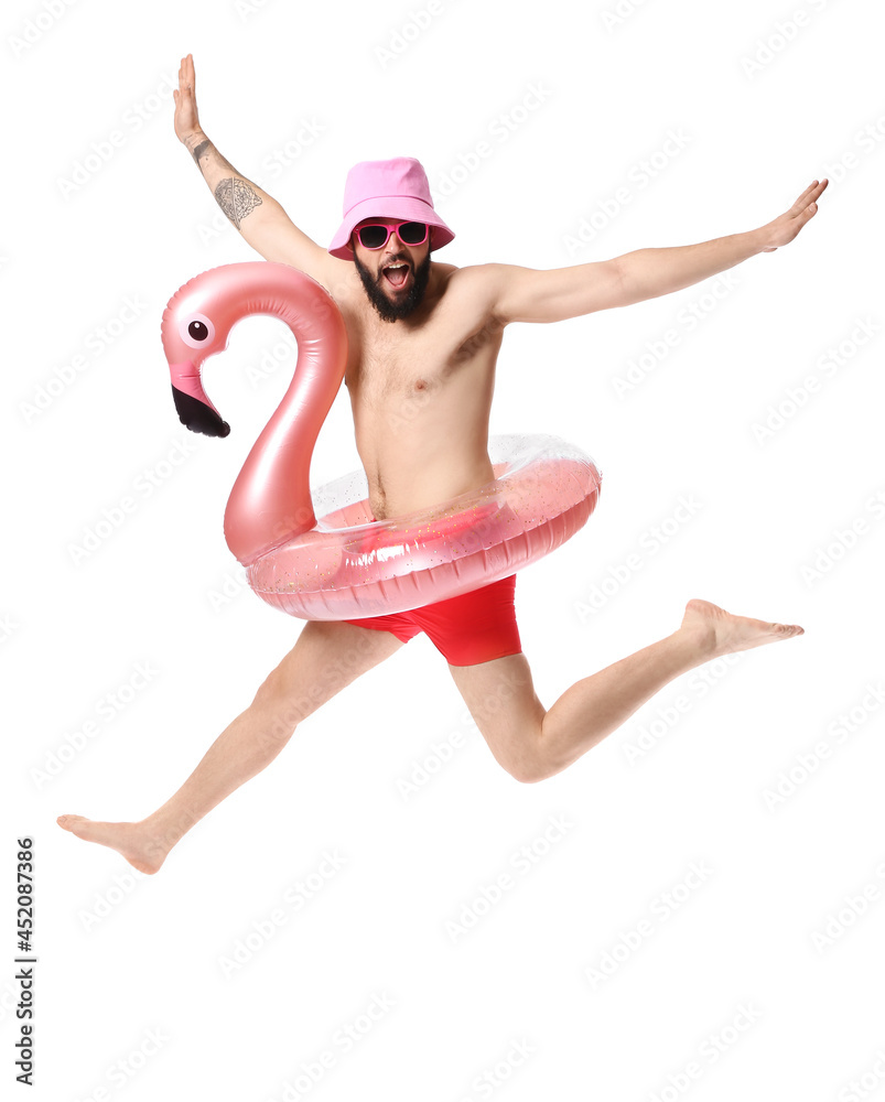 Funny jumping young man with inflatable ring on white background