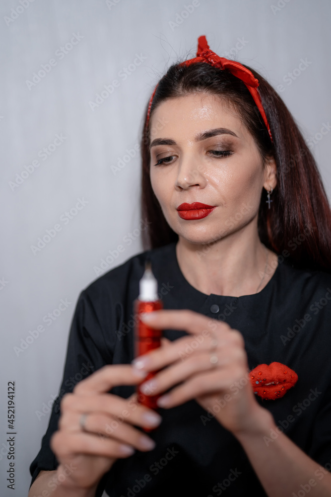 Permanent makeup teacher examining her tool for permanent makeup at the studio. Eyebrow master or ma