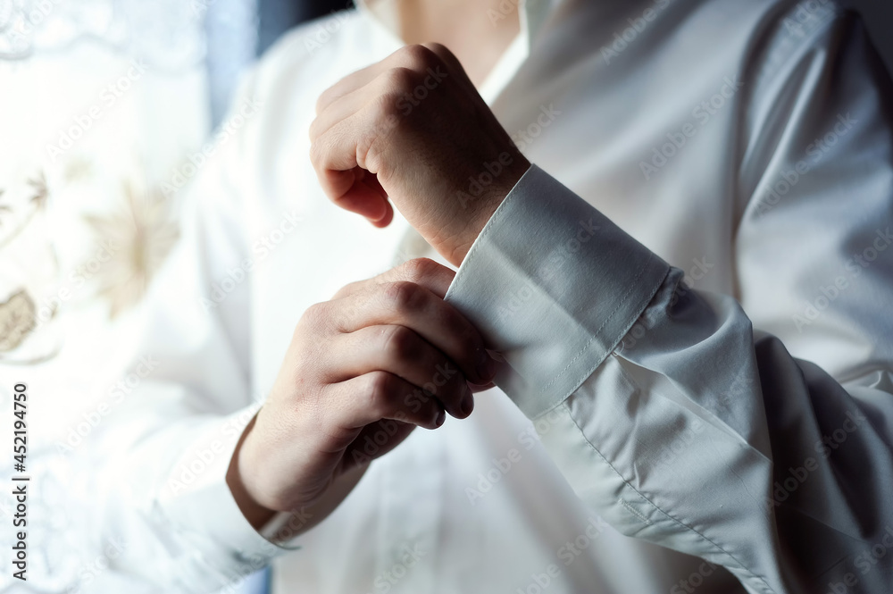 Handsome young groom preparing to his wedding. Grooms morning preparation, groom getting dressed an