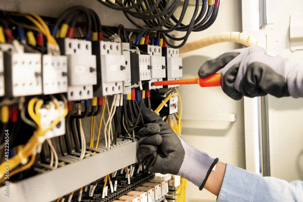 Electricians work to connect electric wires in the system, switchboard, electrical system in Control