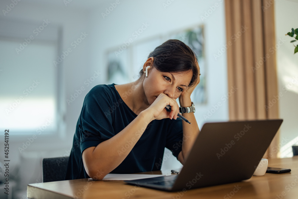 Portrait of a tired businesswoman working overtime at home.