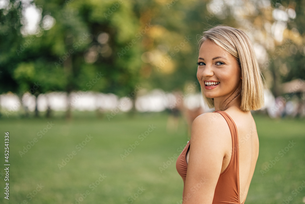 夏日里，一个穿着泳衣微笑的女人看着镜头的肖像。