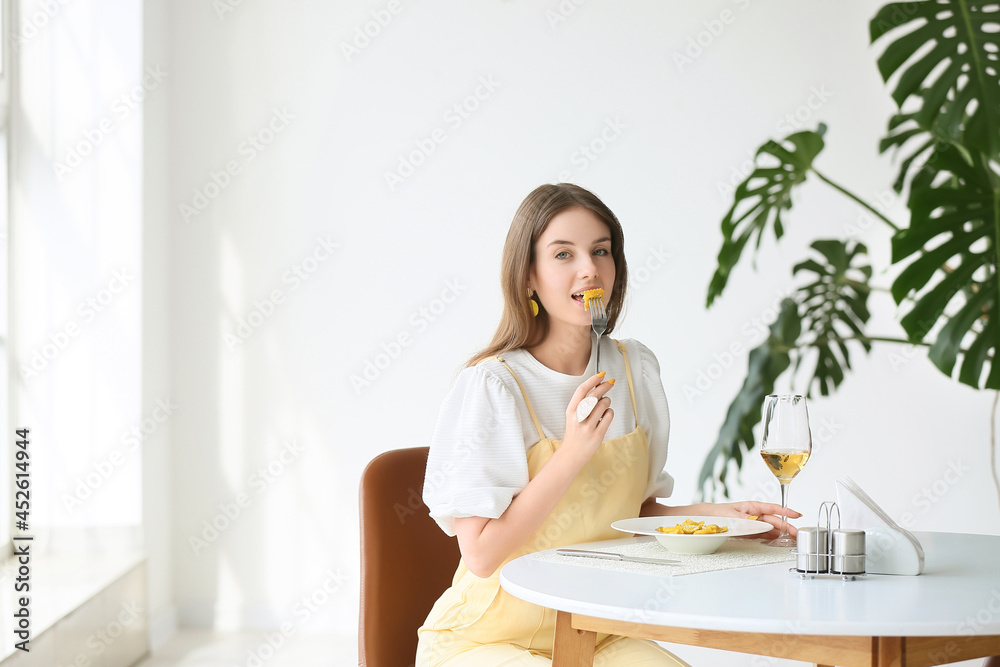 美丽的年轻女子在咖啡馆吃美味的饺子