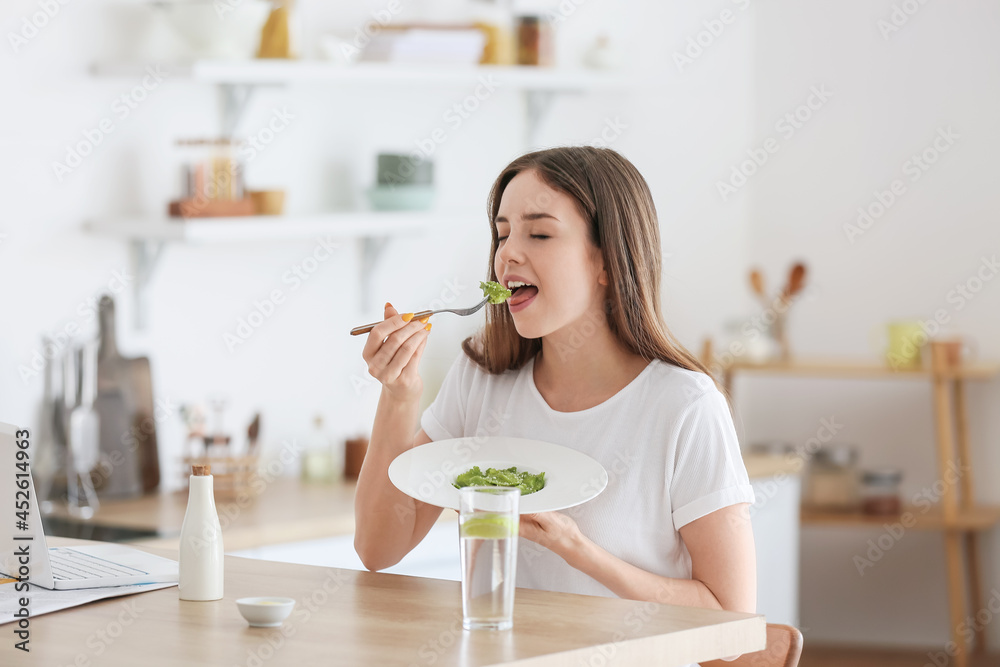 漂亮的年轻女人在家吃美味的饺子