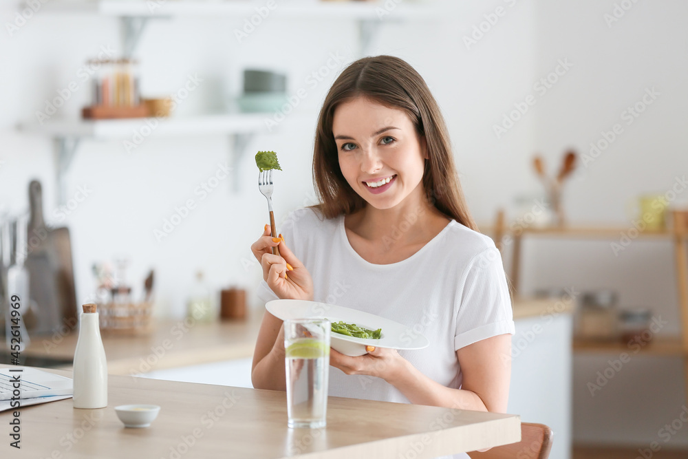 美丽的年轻女子在家吃美味的饺子