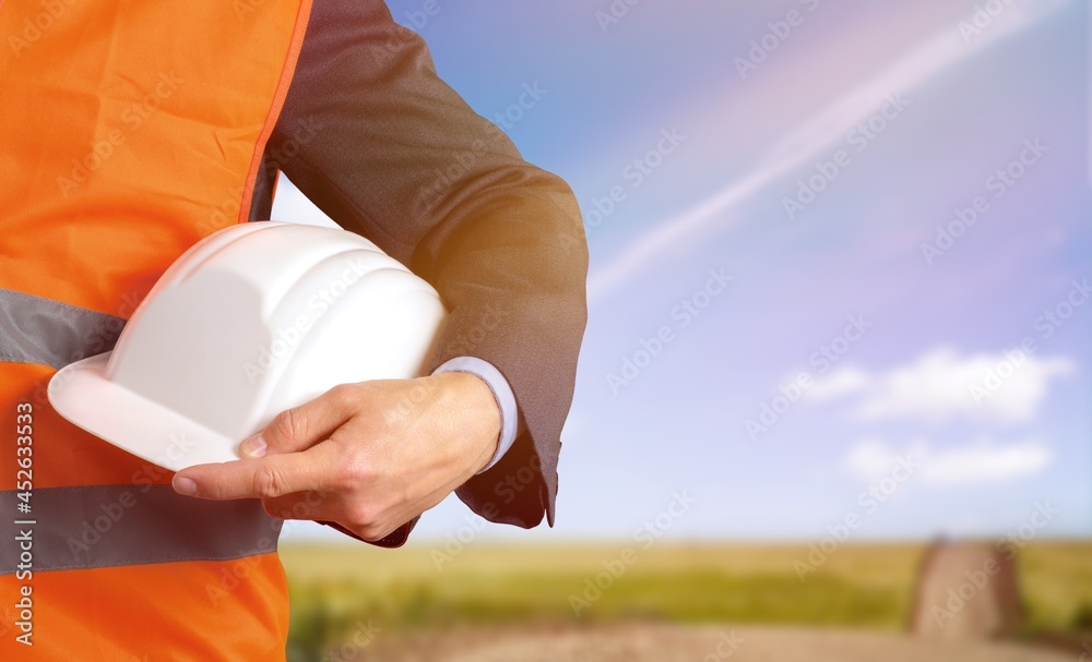 Worker man with helmet in hands on background