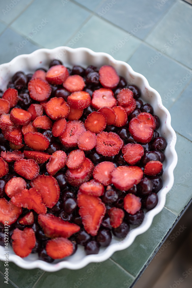 Sliced strawberry and cherry ready for baking for a summer cake, top view