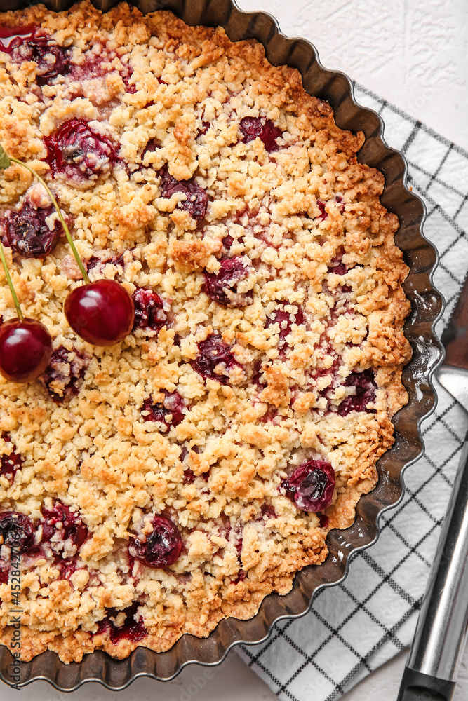 Baking dish with tasty cherry pie on light background, closeup