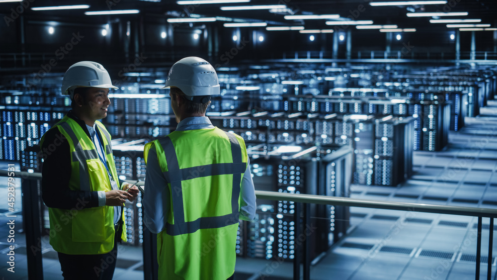 Data Center IT Specialist and System administrator Talk, Use Tablet Computer, Wearing Safety Wests. 