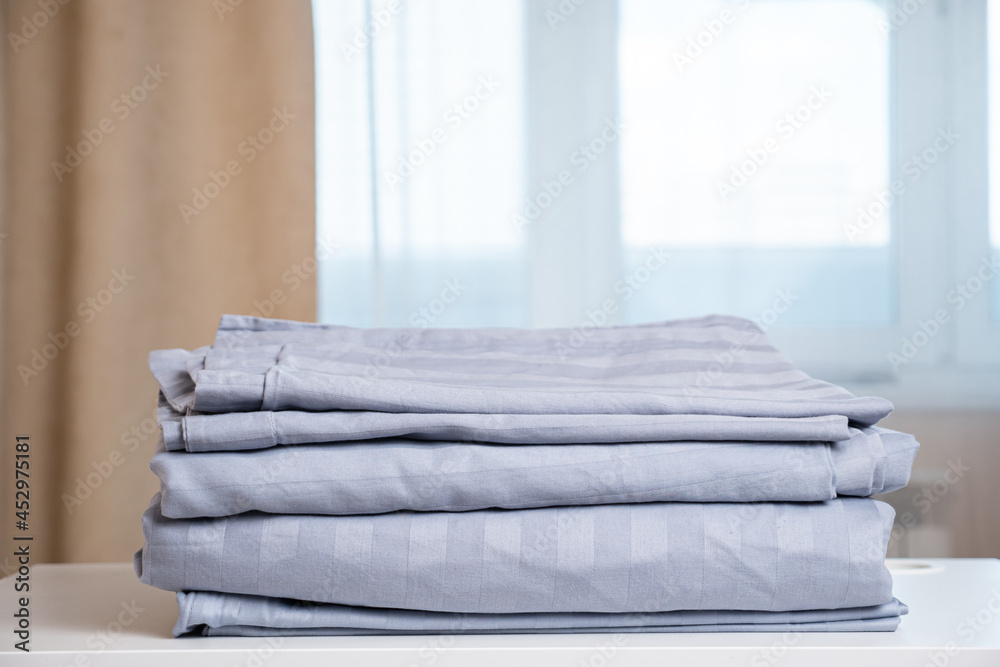 Motion down along high stack of light purple contemporary clean folded ironed linens lying on white 