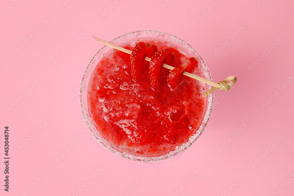 Glass of tasty strawberry margarita on color background