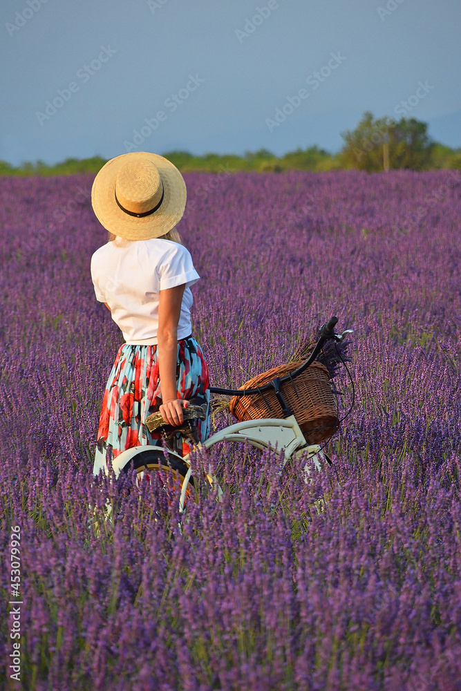 Young woman with bicycle in lavender field