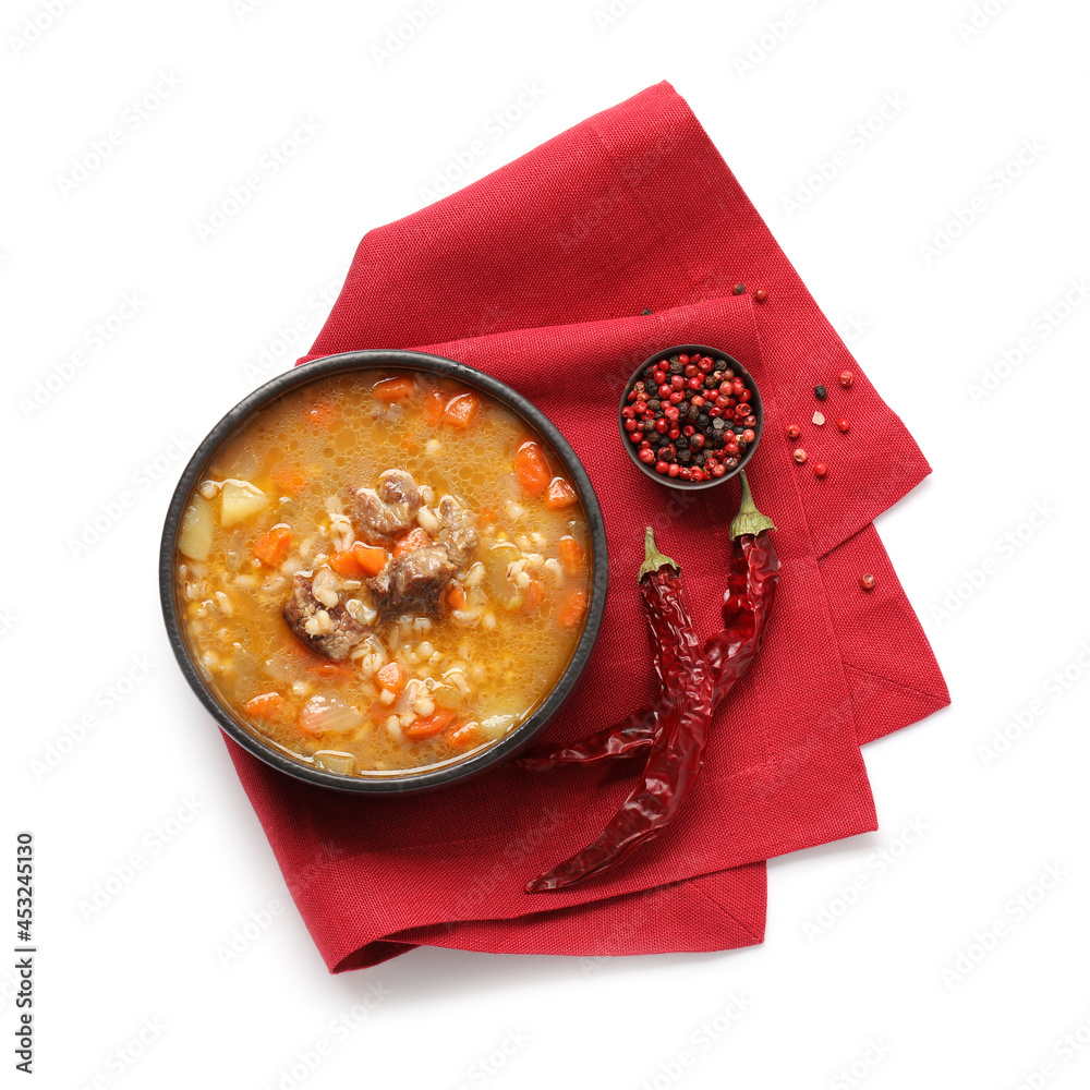 Bowl with tasty beef barley soup on white background