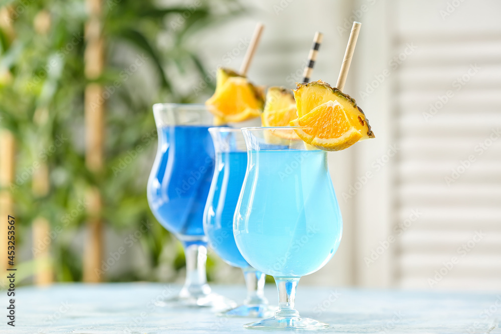 Glasses of Blue Lagoon cocktail on table in room