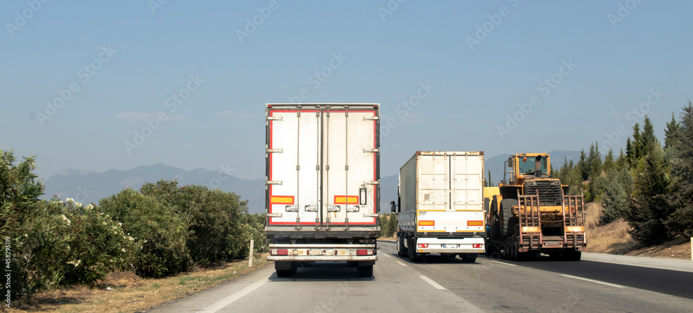 公路上并排行驶的大型和重型车辆。交通产生了卡车。