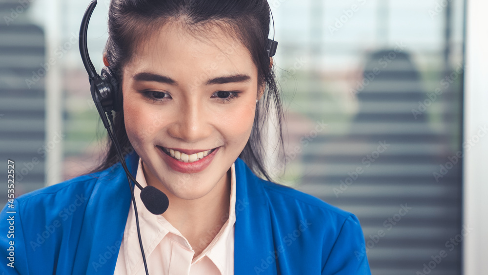 Businesswoman wearing headset working actively in office . Call center, telemarketing, customer supp