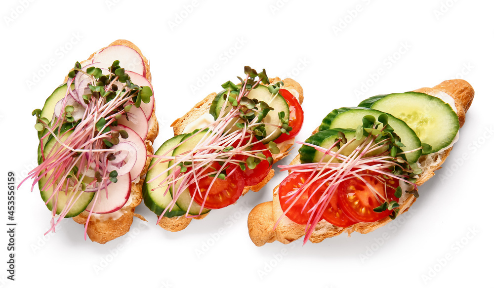 Tasty croissants with vegetables and micro green on white background