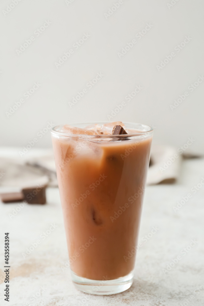 Glass of tasty chocolate milk on light background