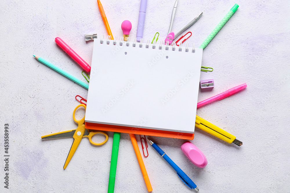 Blank notebook and stationery supplies on light background