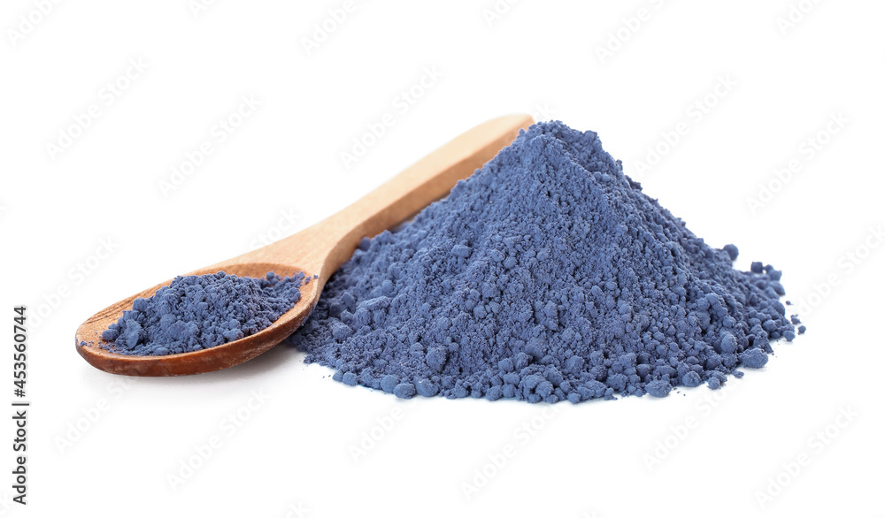 Heap of powdered blue matcha tea and spoon on white background