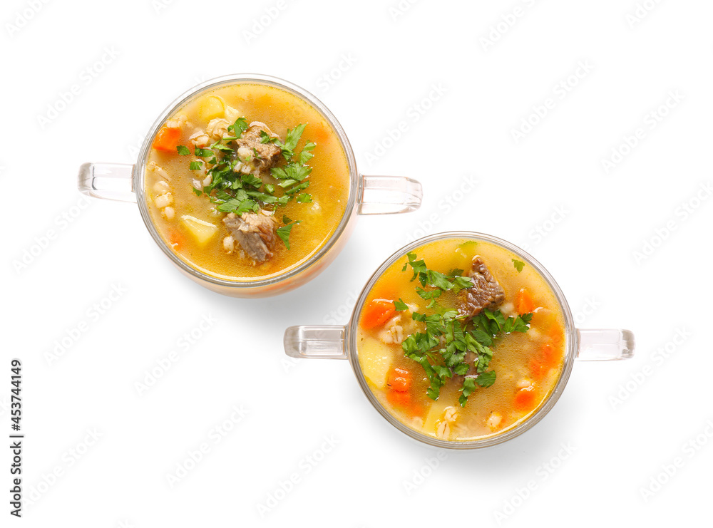 Bowls with tasty beef barley soup on white background