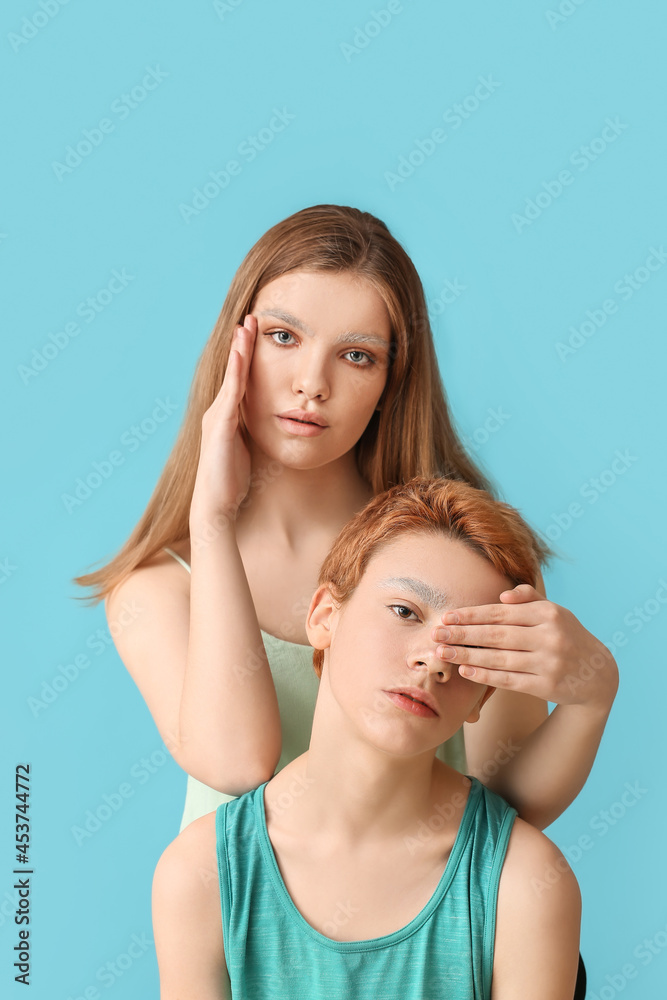 Teenagers with dyed eyebrows on color background