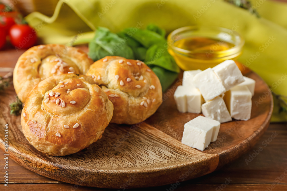 Puff pastry stuffed with spinach and feta cheese on wooden background